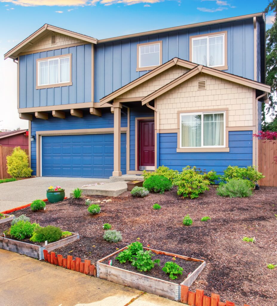 Nice curb appeal of blue house with front garden. 
