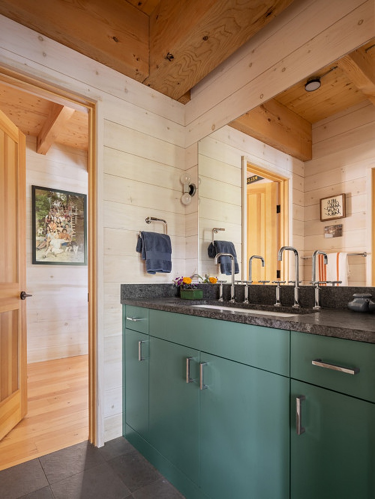 rustic bathroom with green cabinetry