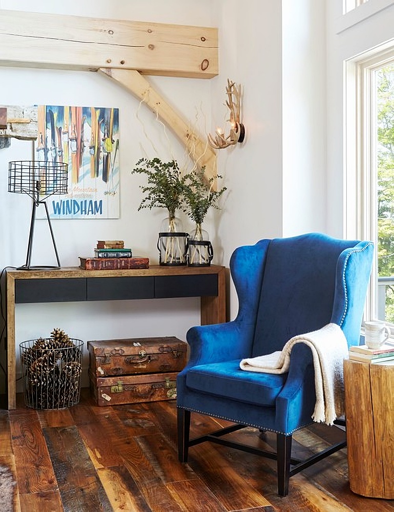 velvet blue wing chair in living room with rustic wood floors