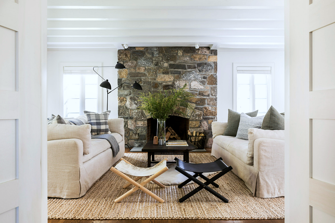 pair of linen sofas in living room with stone fireplace