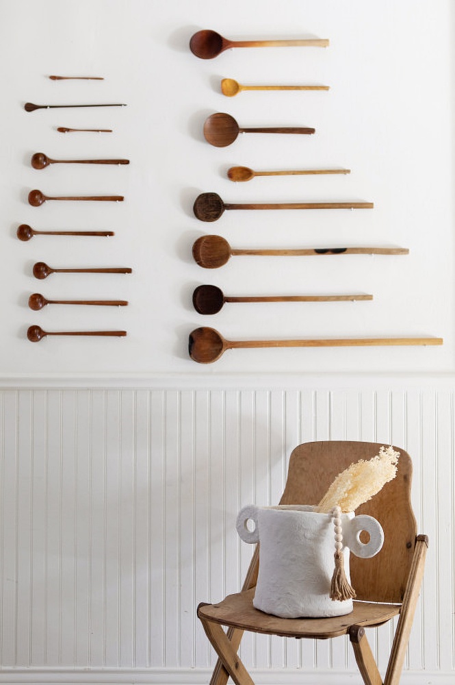old wooden spoons displayed on kitchen wall