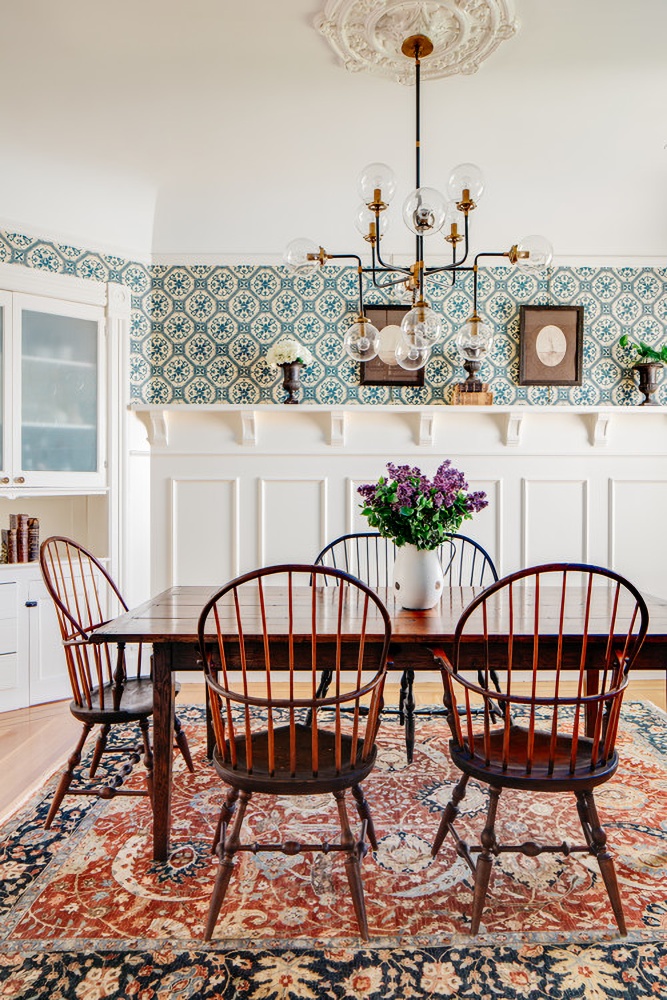 Patterned wallpaper and rug in traditional dining room