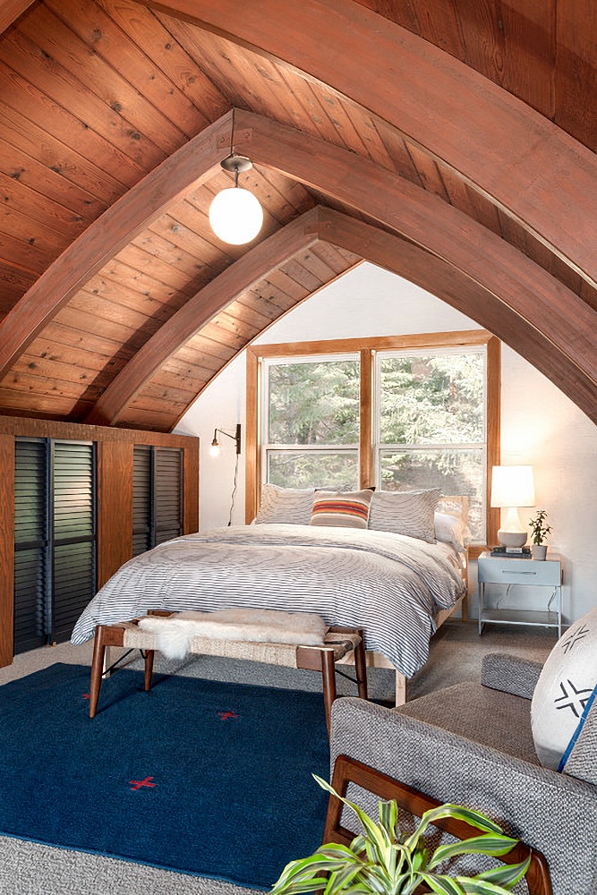 cabin bedroom with vaulted wood ceiling