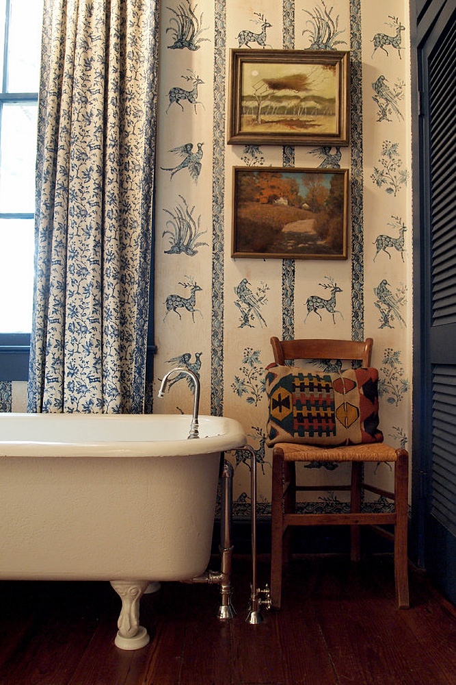 animal wallpaper in a vintage bathroom with claw foot tub