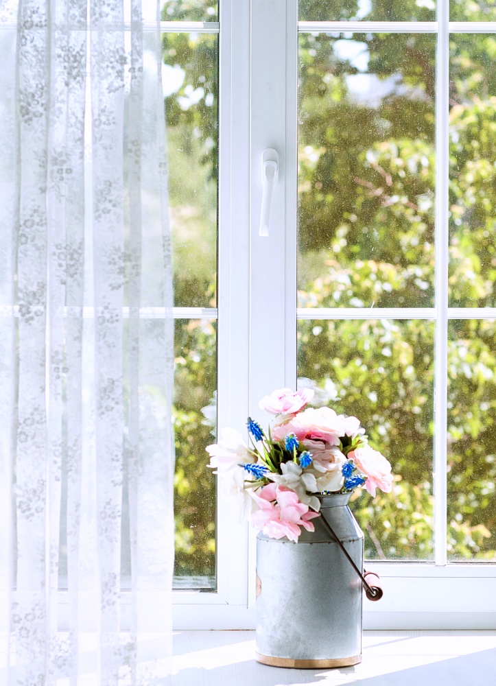 Window with lace curtains and flowers