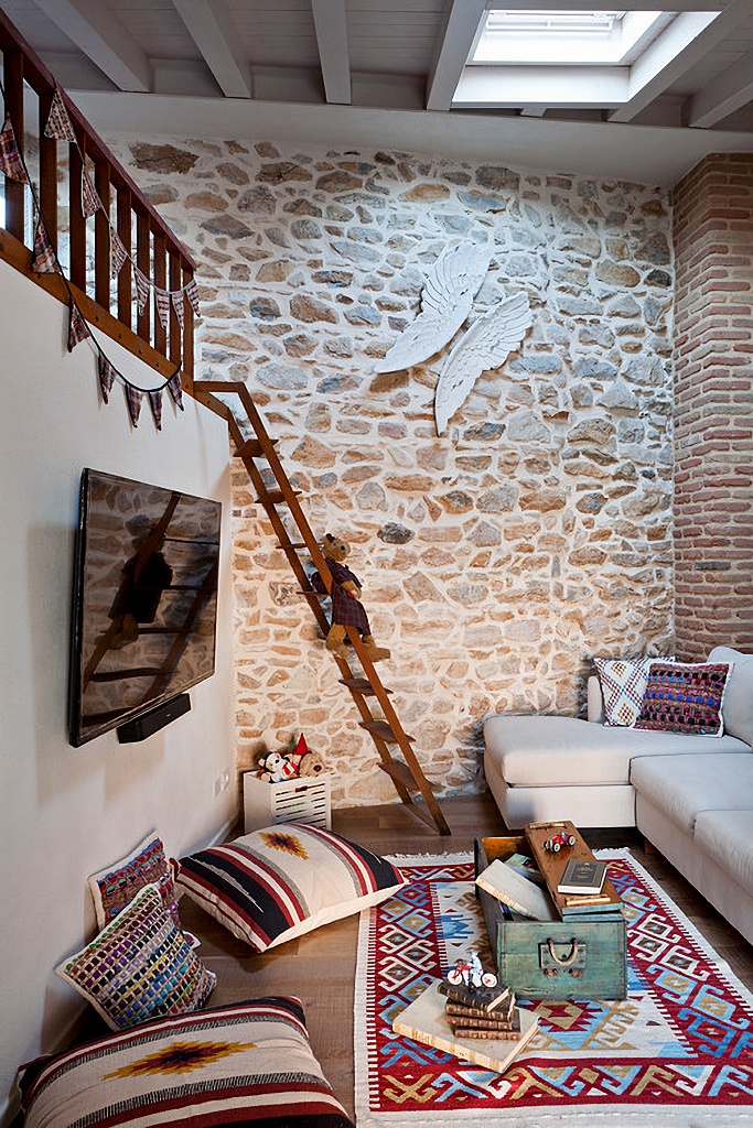 Italian family room with exposed stone wall