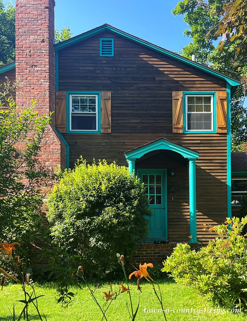 turquoise door on dark brown house