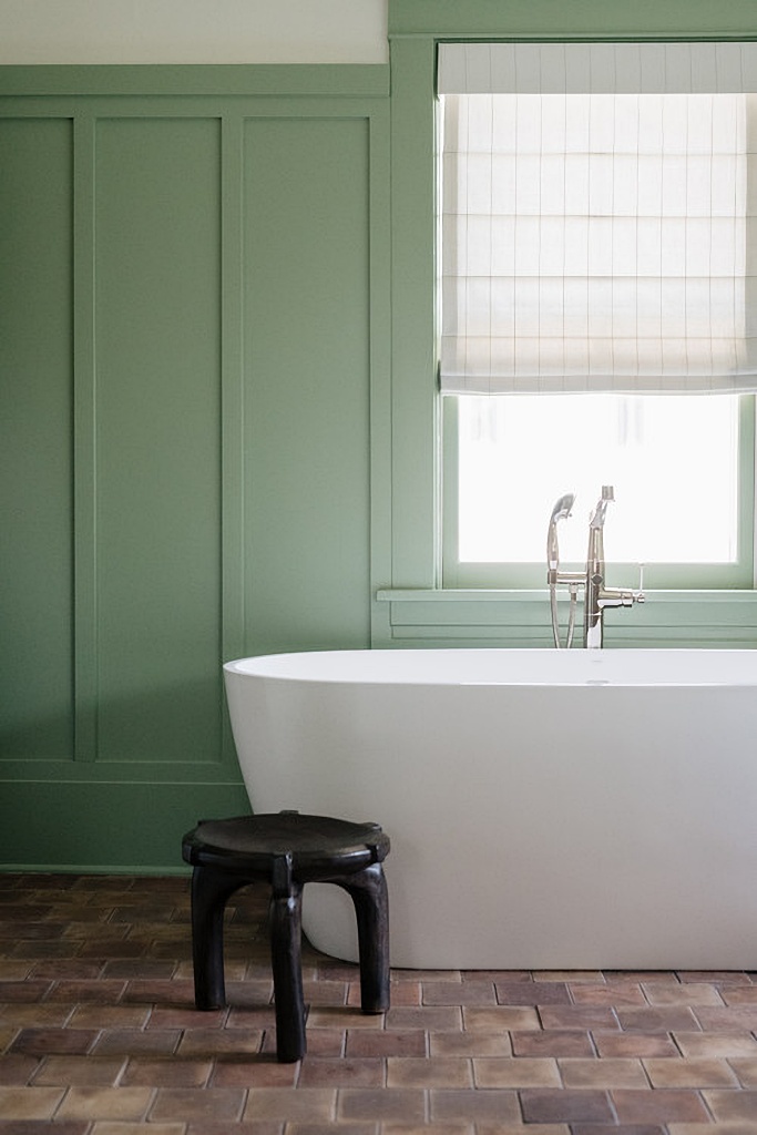 sage green bathroom with white freestanding tub