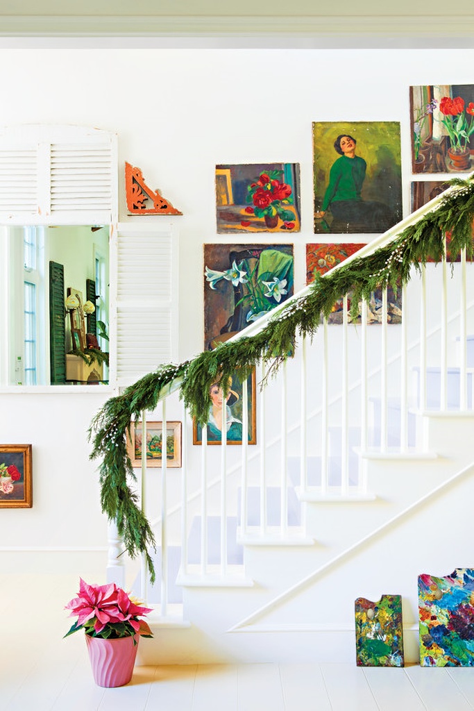 holiday staircase with oil paintings and Christmas greenery