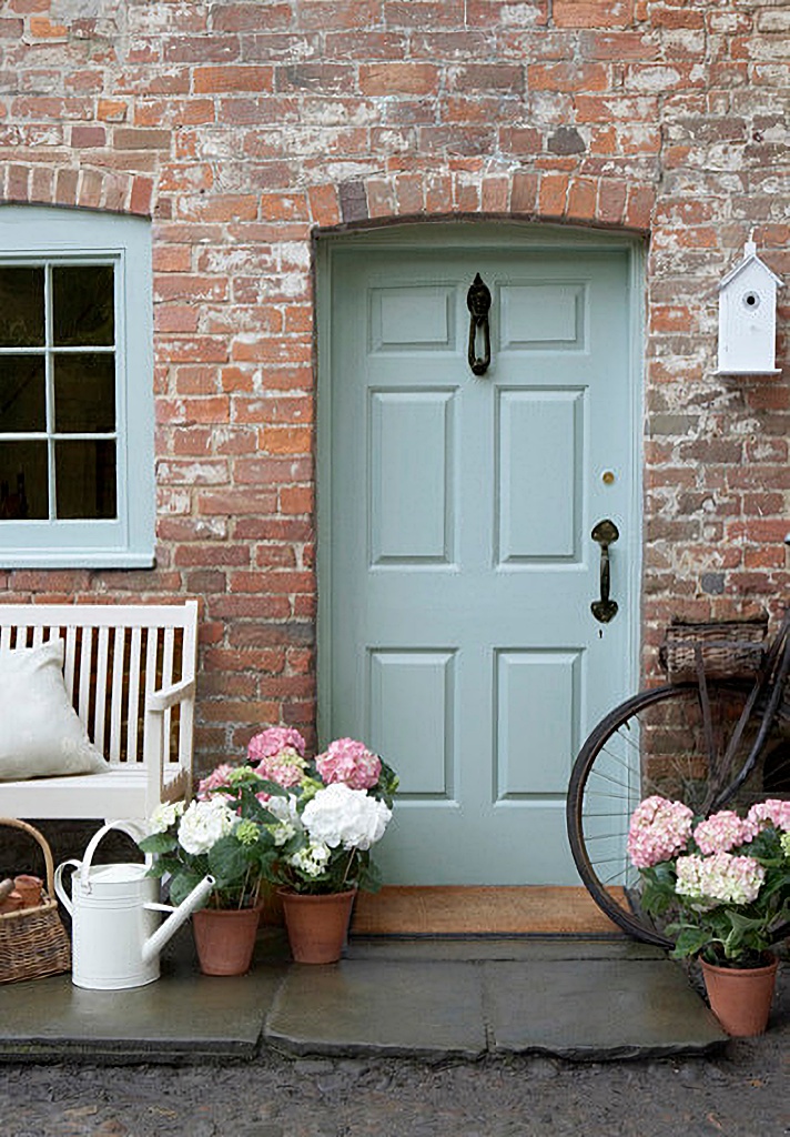 pale blue front door on brick cottage