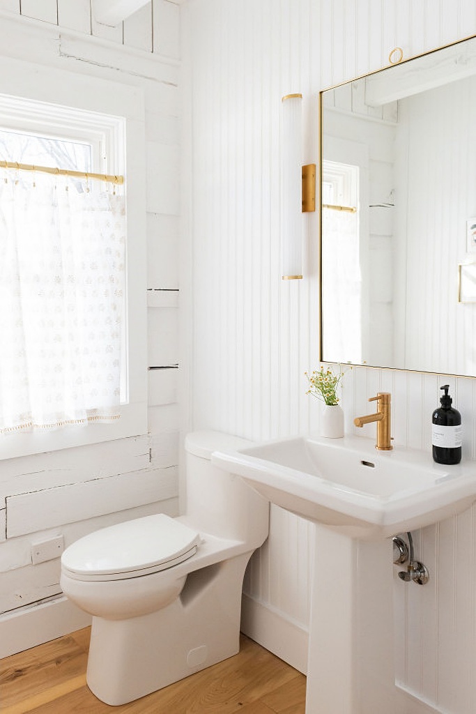 white powder room with brushed gold hardware