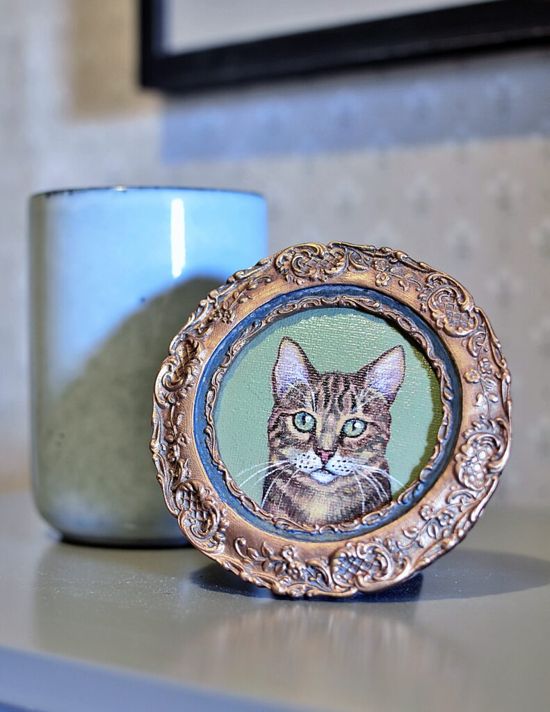 Framed round oil painting of a sweet cat