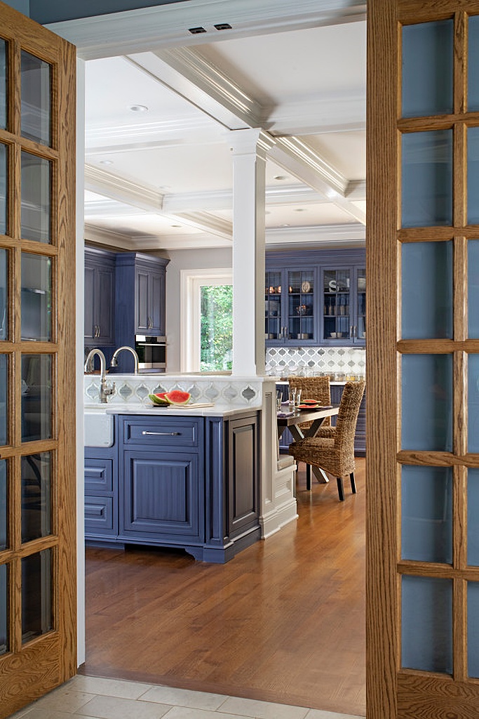 wood French doors leading into custom blue kitchen