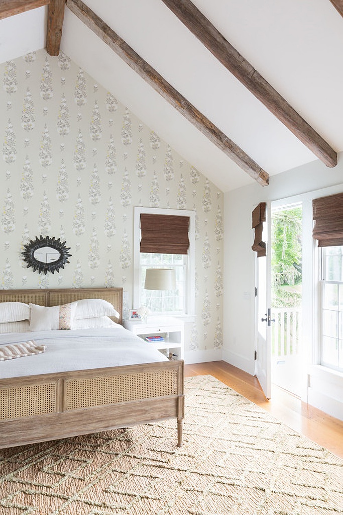 Vaulted ceiling in neutral bedroom with wallpapered accent wall