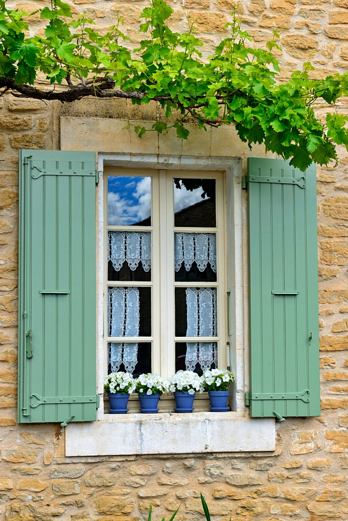 old-fashioned cottage window with painted shutters