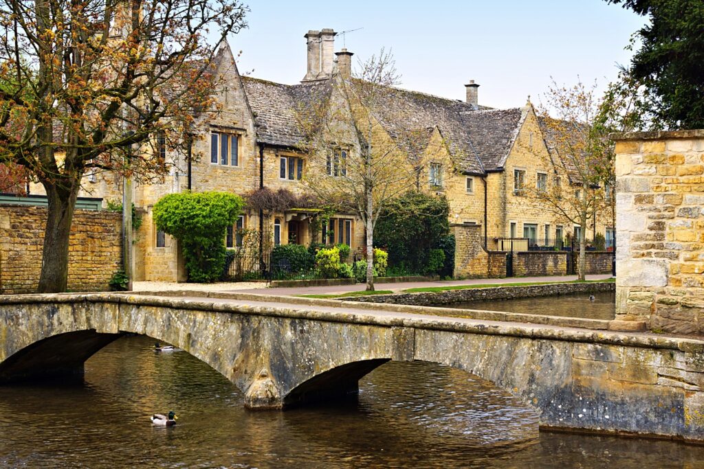 Idyllic Cotswolds village of Bourton on the Water with bridge and stone houses along the River Windrush, England