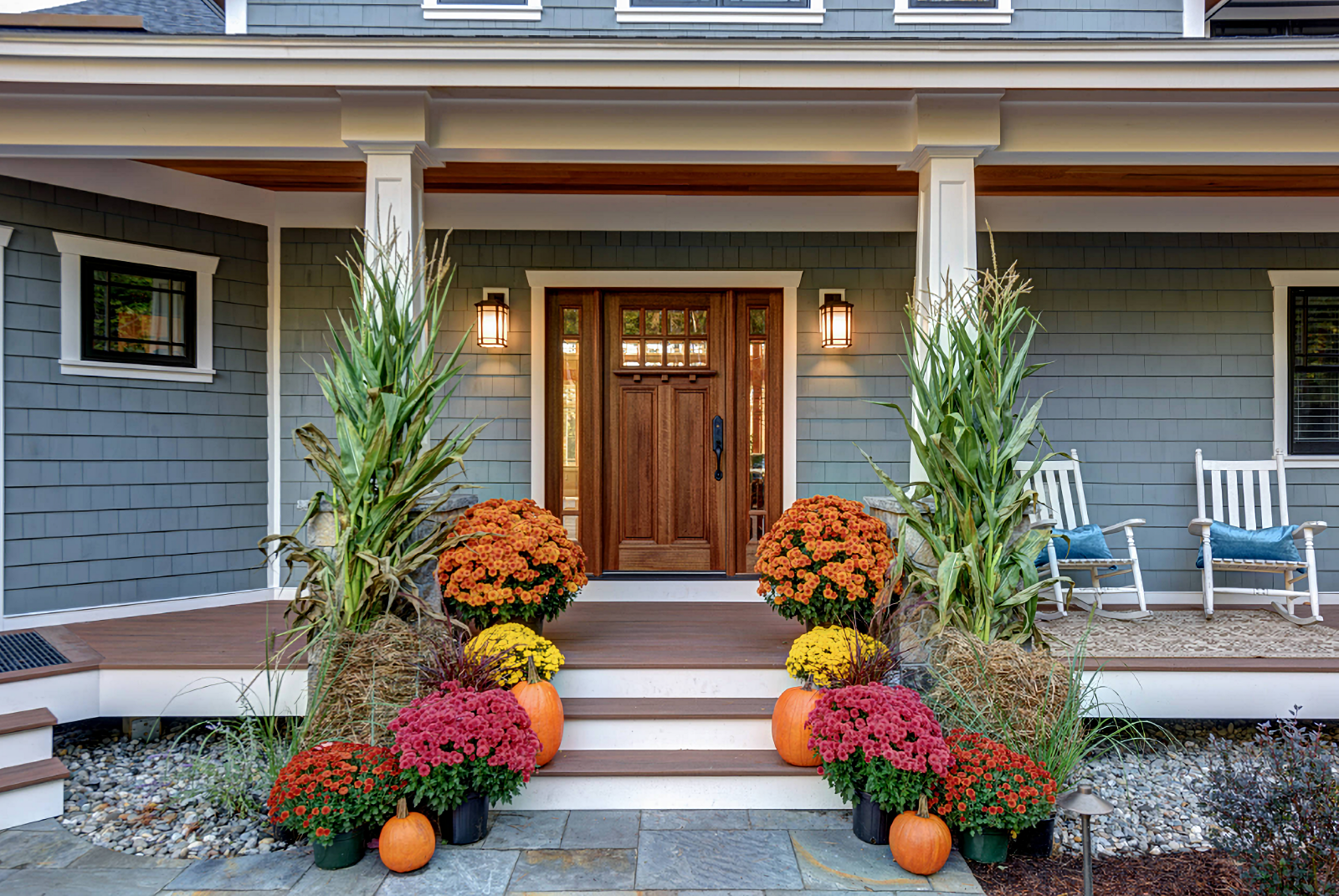 large porch with cornstalks and mums