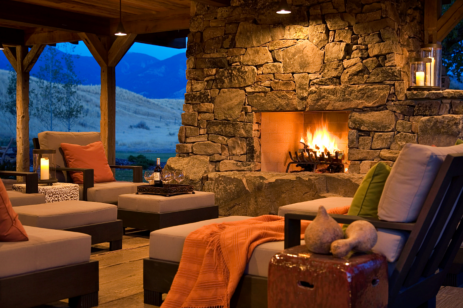 rustic covered porch with stone fireplace