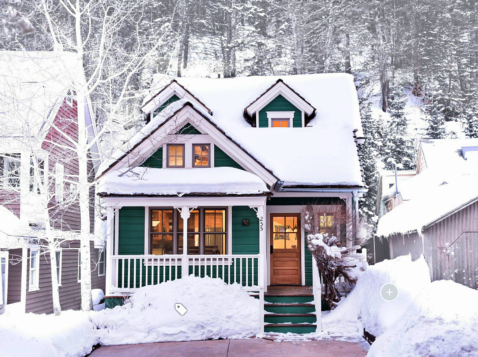 snow-covered homes. green Victorian bungalow