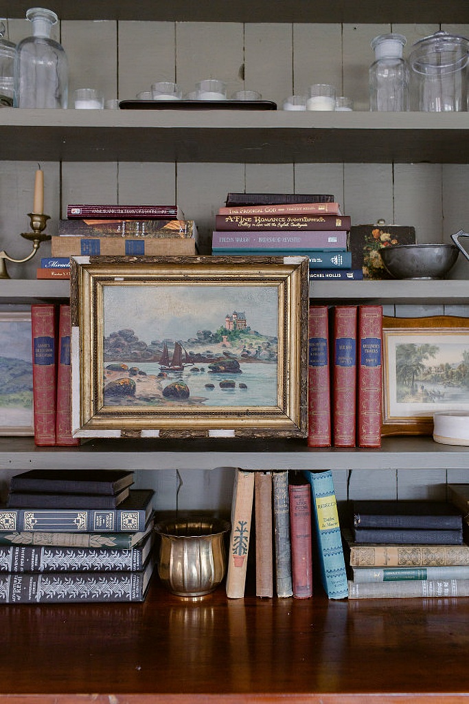 book shelf with oil painting