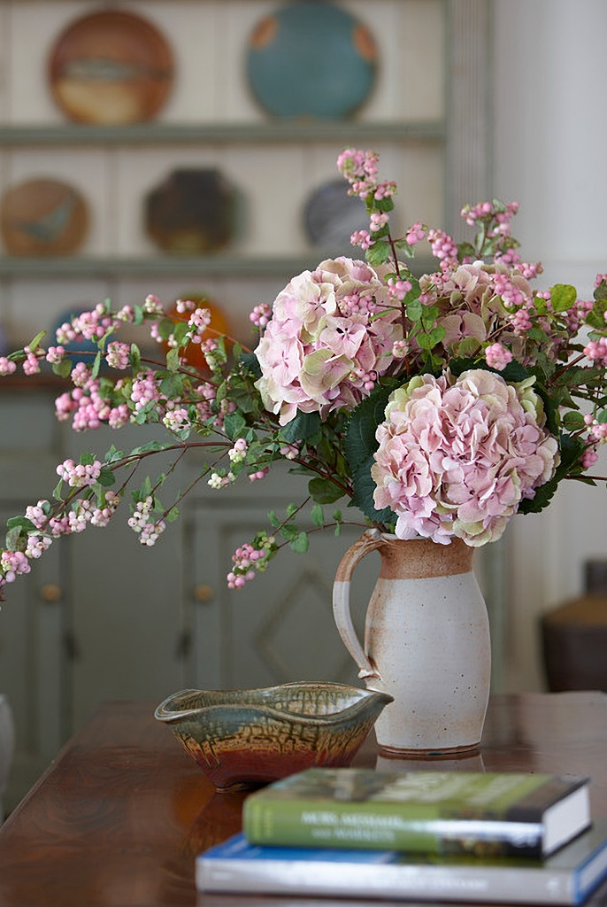 pink flowers in a stoneware pitcher