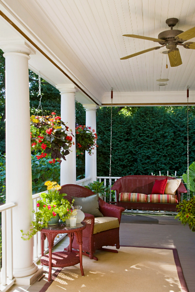 red wicker furniture on traditional front porch