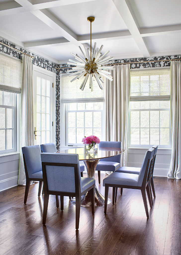 wallpapered dining room with blue upholstered chairs