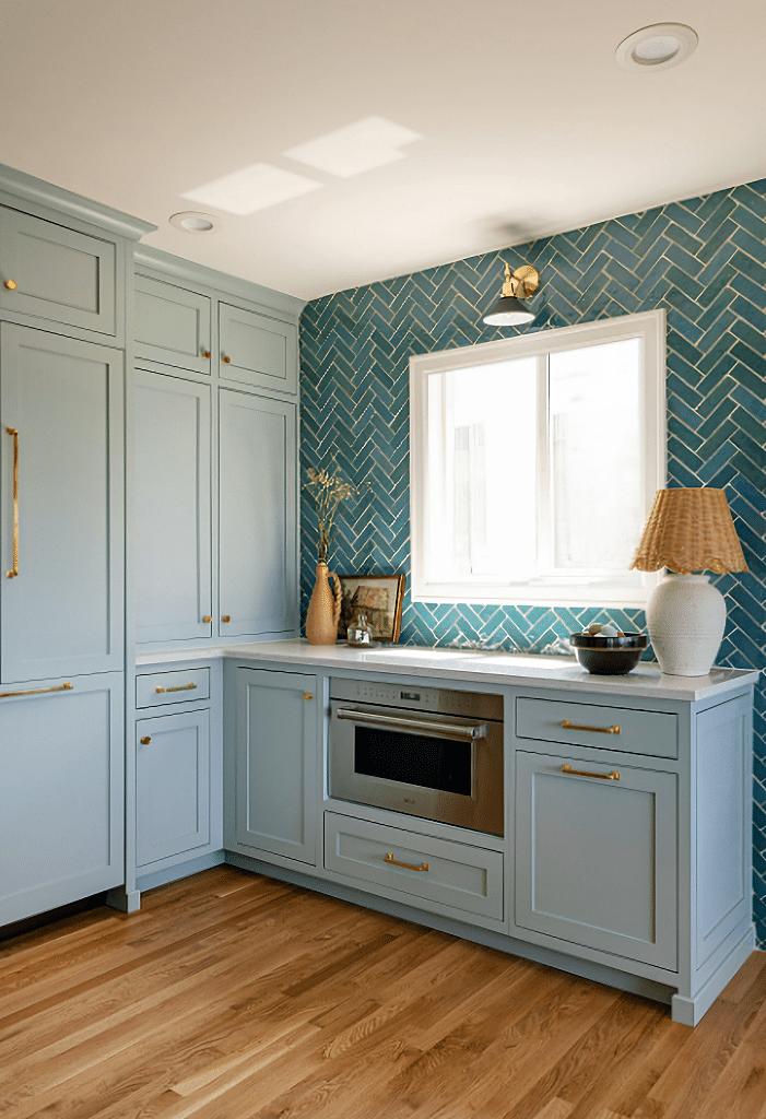 light blue kitchen cabinetry with brass hardware