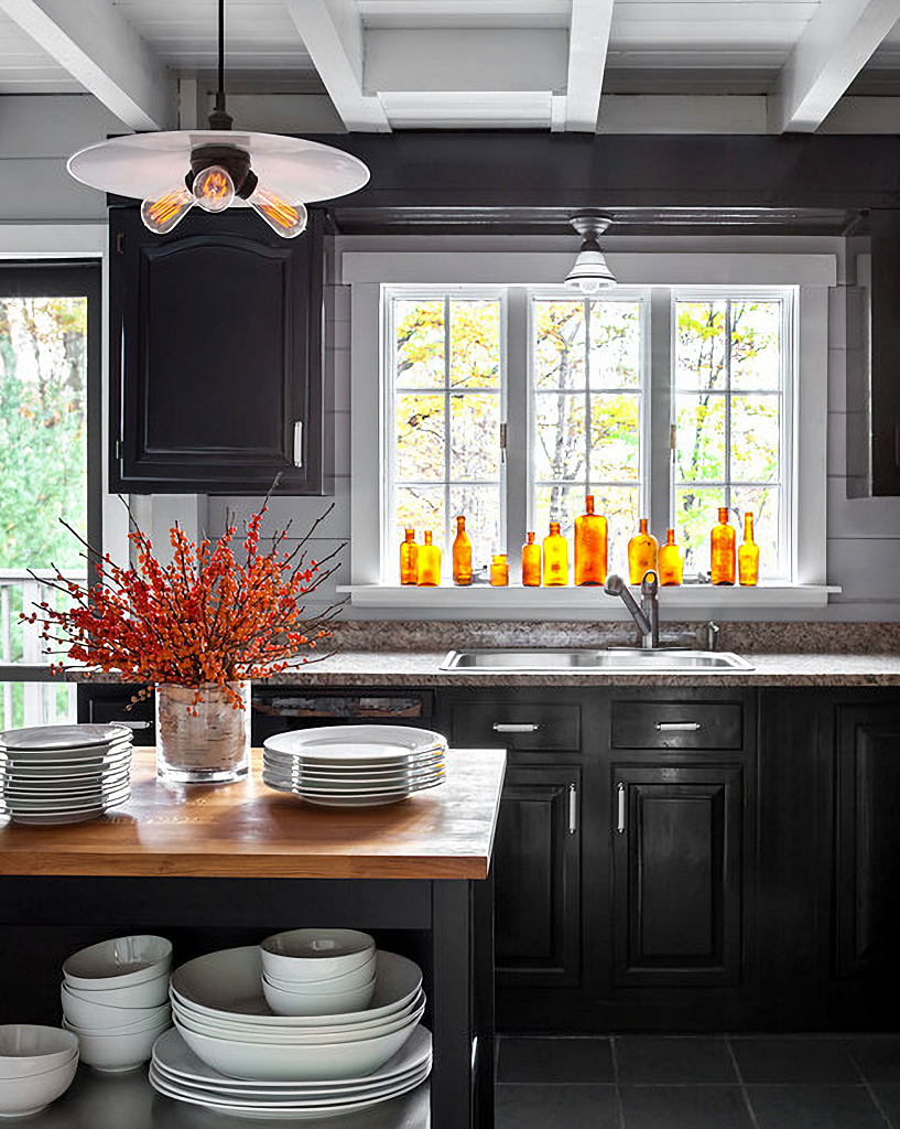 dark and moody kitchen with amber bottles on windowsill