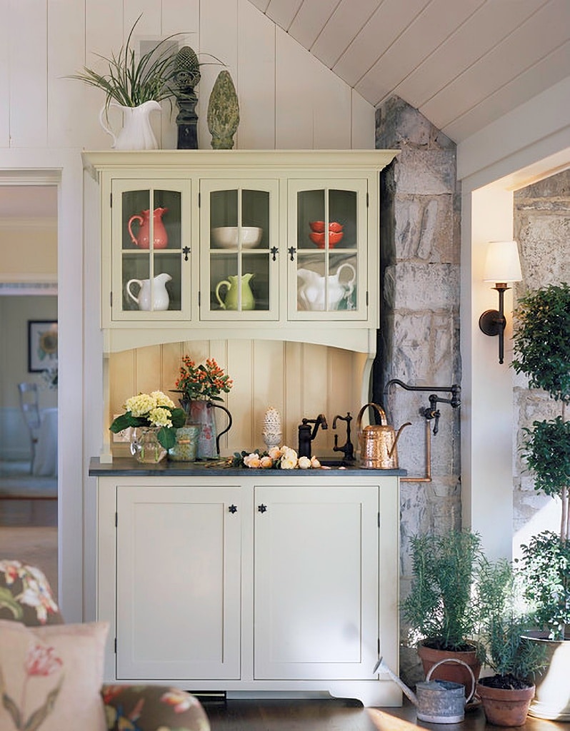 cottage cabinet filled with colorful pottery