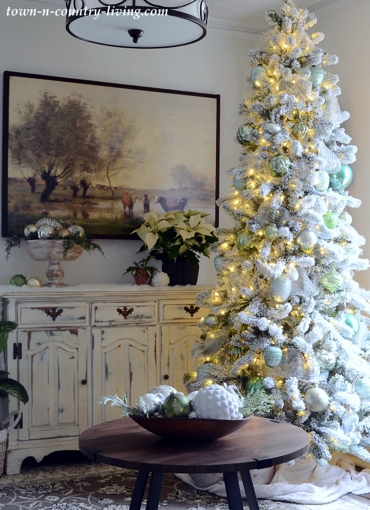 green ornaments on flocked tree