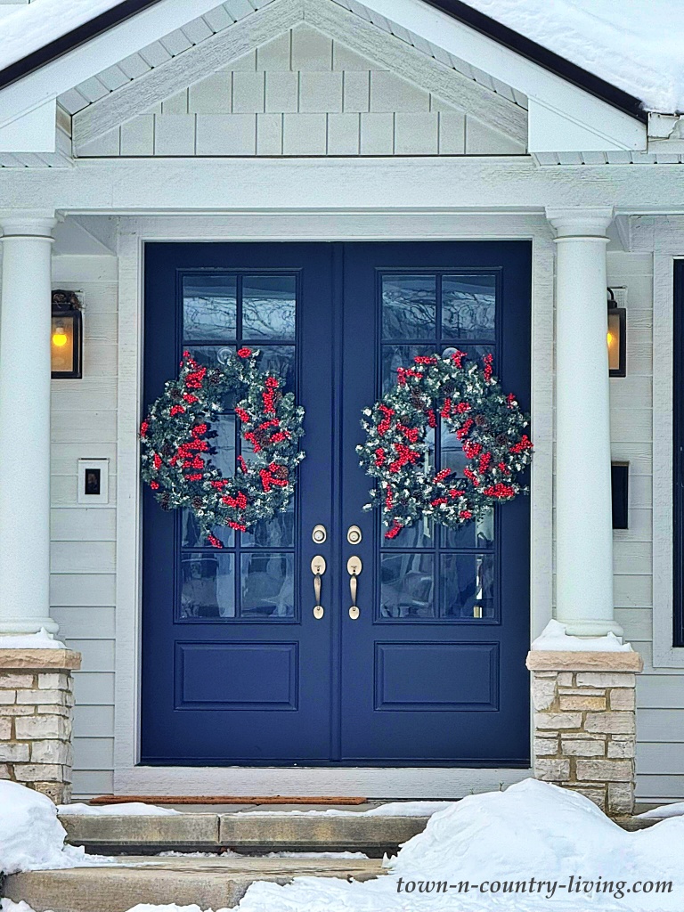 blue double doors with Christmas wreaths