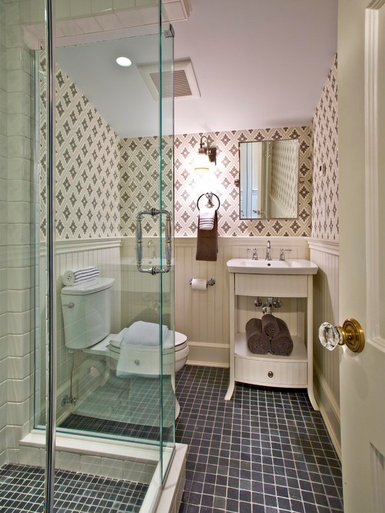 Small, classic bathroom with wallpaper and glass shower