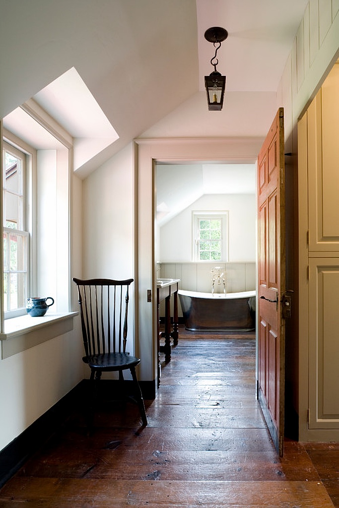 wide plank wood floors in hallway leading to bathroom