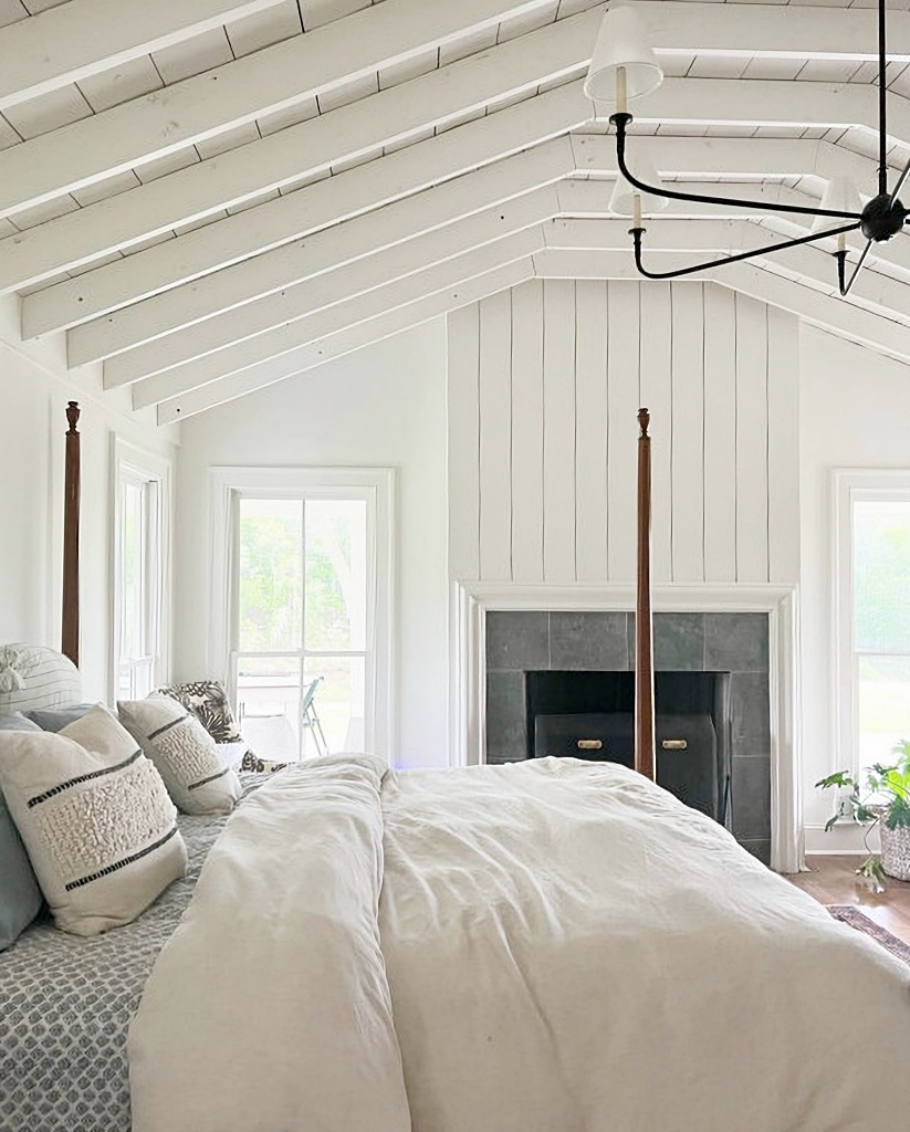 four-poster bed in farmhouse bedroom with fireplace