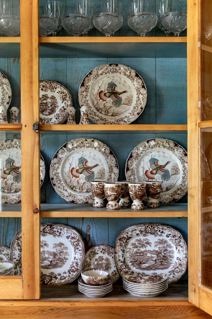 brown and white transferware in hutch