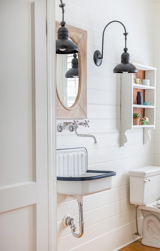 metal wall-mounted sink in black and white bathroom
