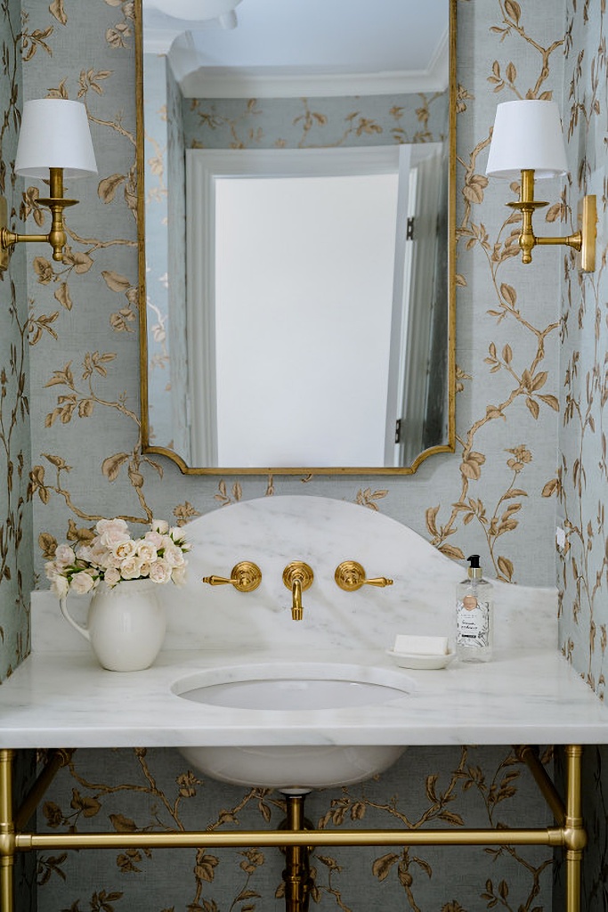 pretty powder room with wallpaper and brass accents