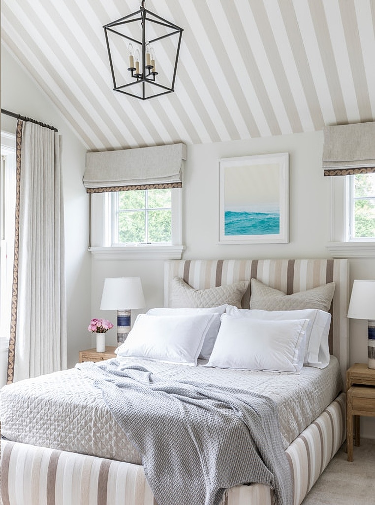 Neutral, peaceful bedroom with striped headboard and ceiling