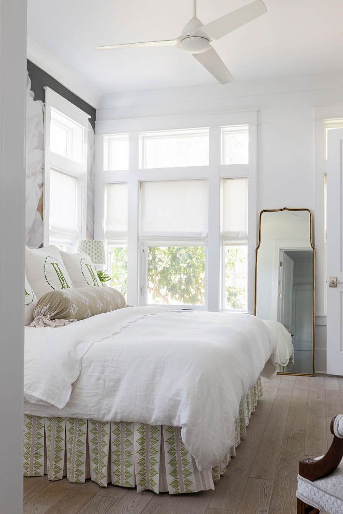 serene primary bedroom with large windows