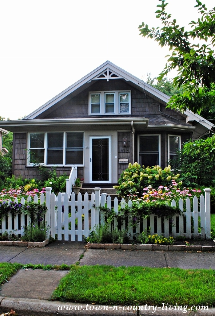 gray cottage with white picket fence