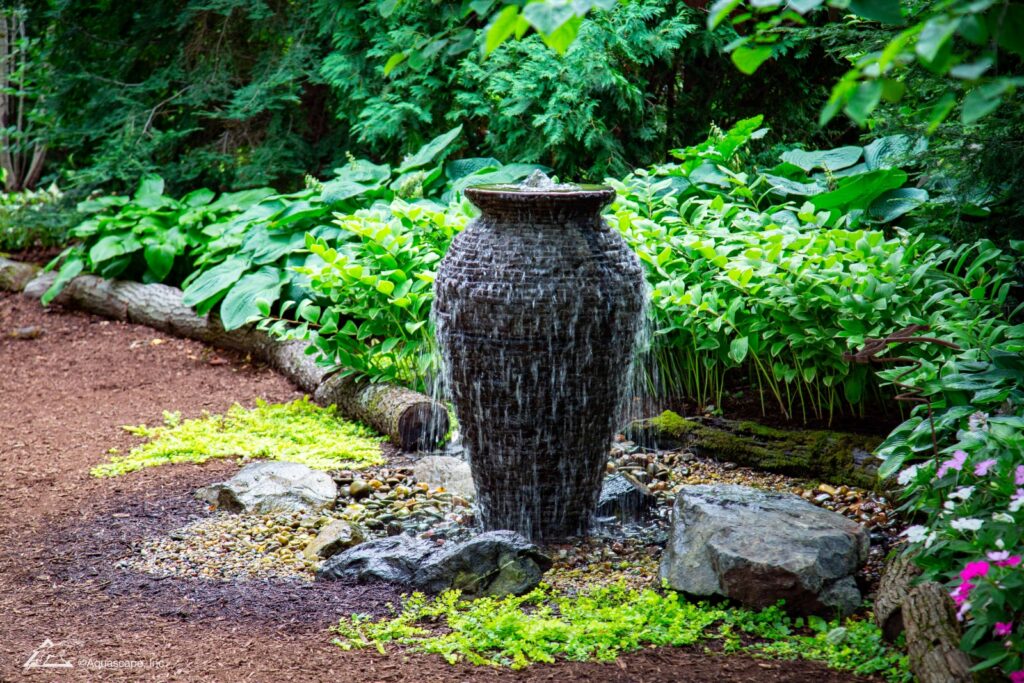 Stacked slate urn fountain on garden path