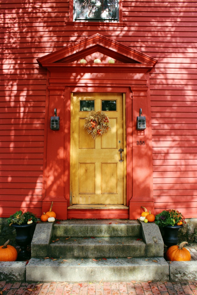red historic home with yellow door
