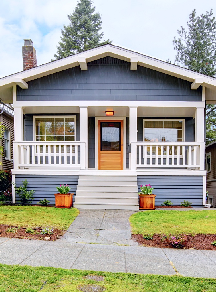 Small blue house with white porch exterior.