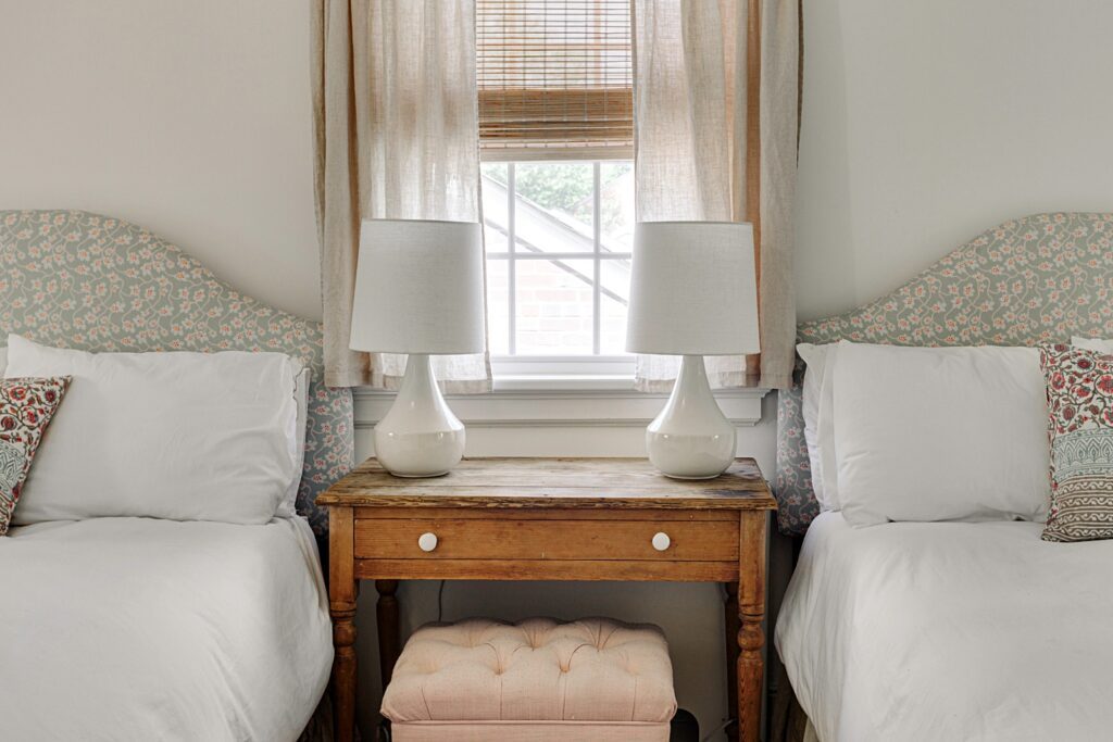 Twin Beds With Patterned Headboards and Soft Lamps