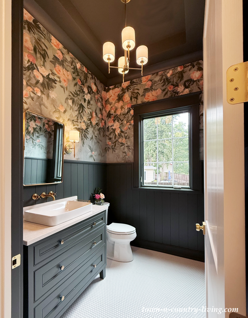 dramatic powder room with bold floral wallpaper and dark green wainscoting