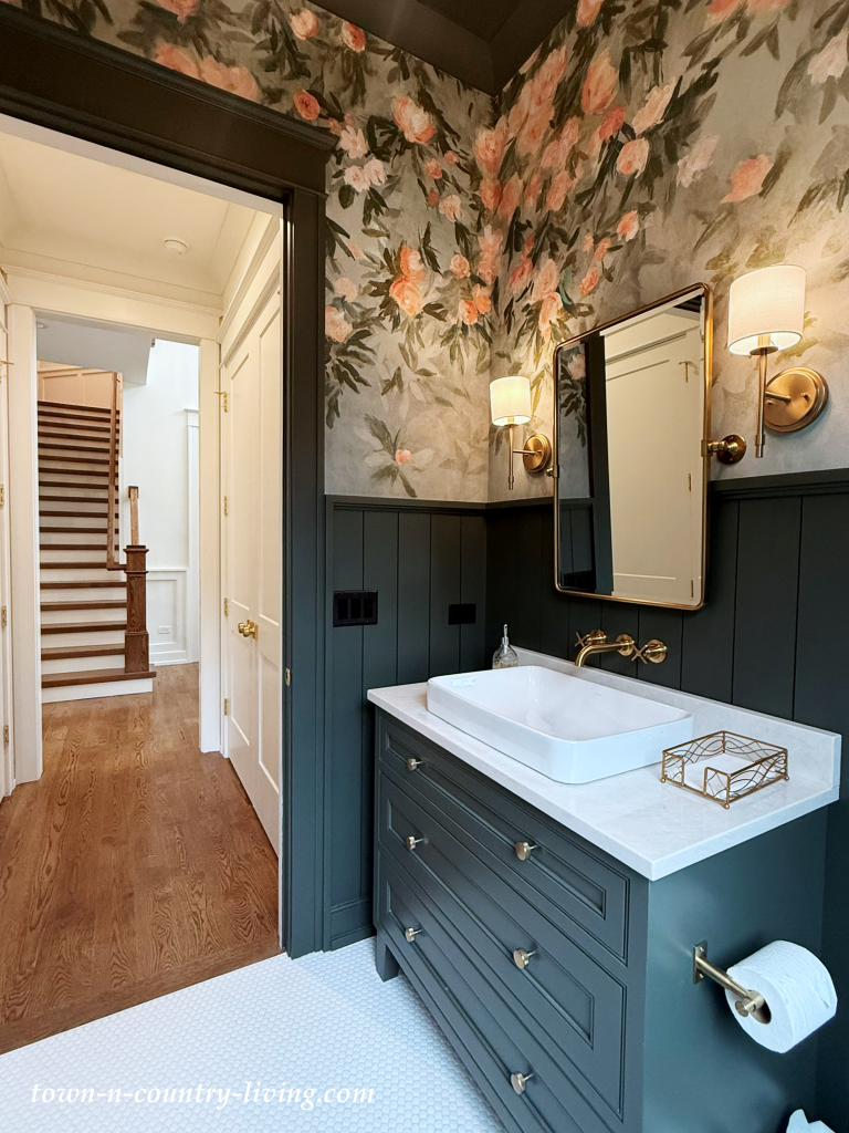 dramatic powder room with bold floral wallpaper and dark green wainscoting