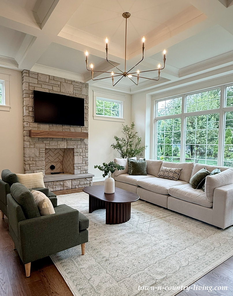 spacious family room with wall of windows and stone fireplace
