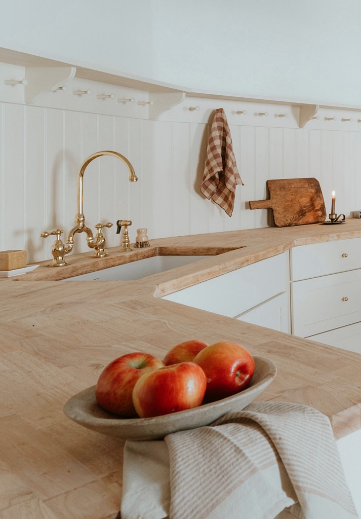 light wood counter tops with cream colored kitchen cabinets