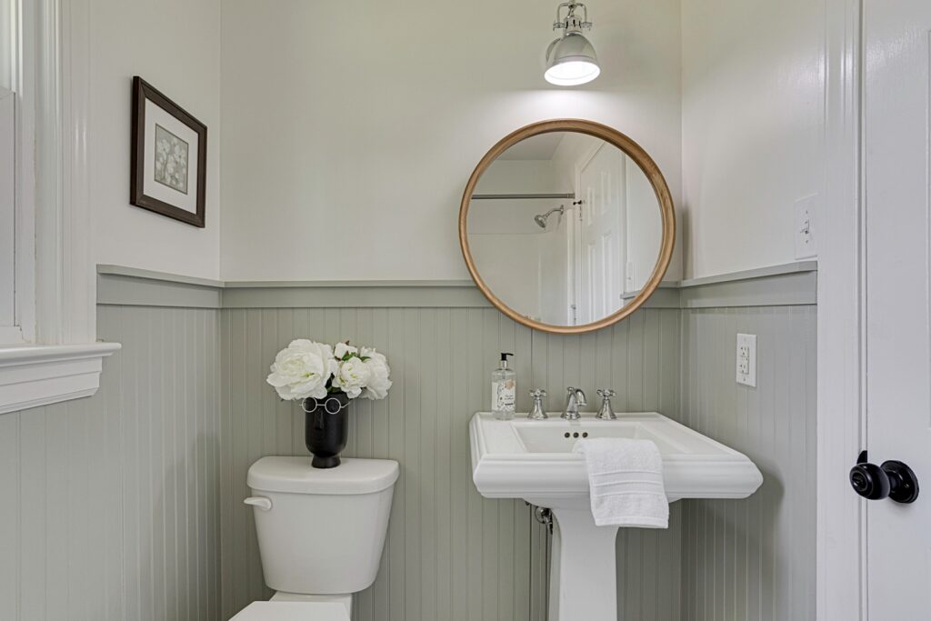 Elegant Bathroom With Vessel Sink And Round Mirror.